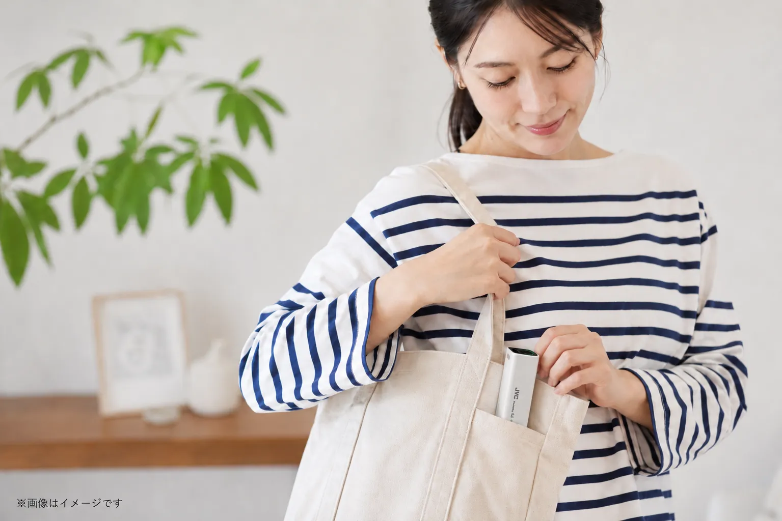 外出時にモバイルバッテリーBH-U4をトートバッグに入れる女性
